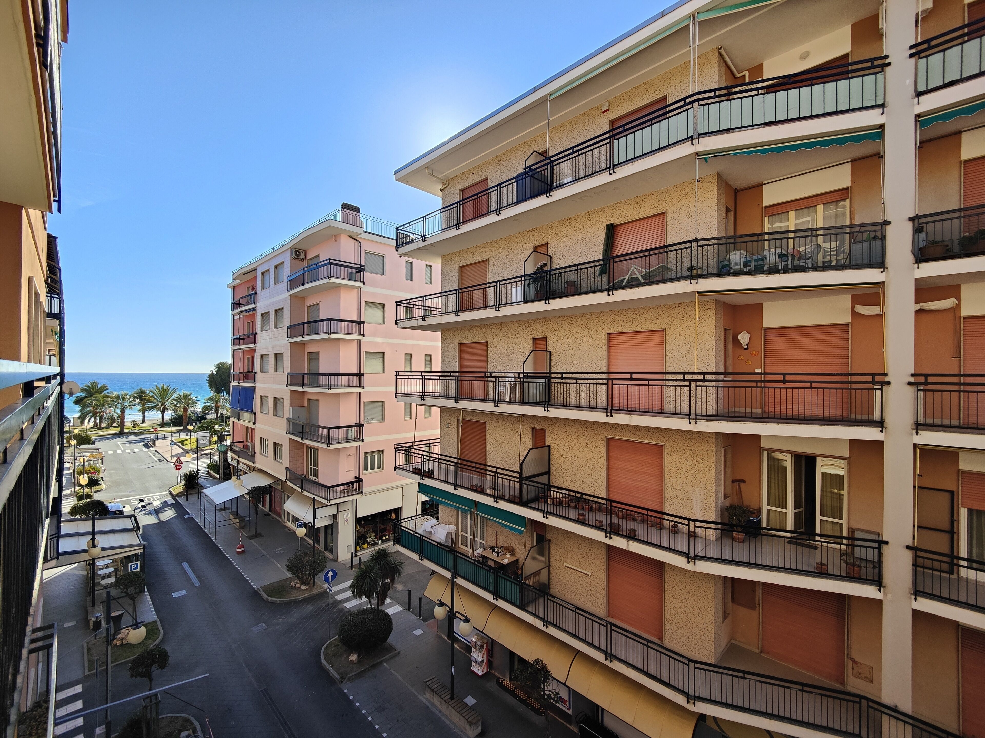 Un hotel a più piani con balconi, vista sulla strada e cielo sereno.