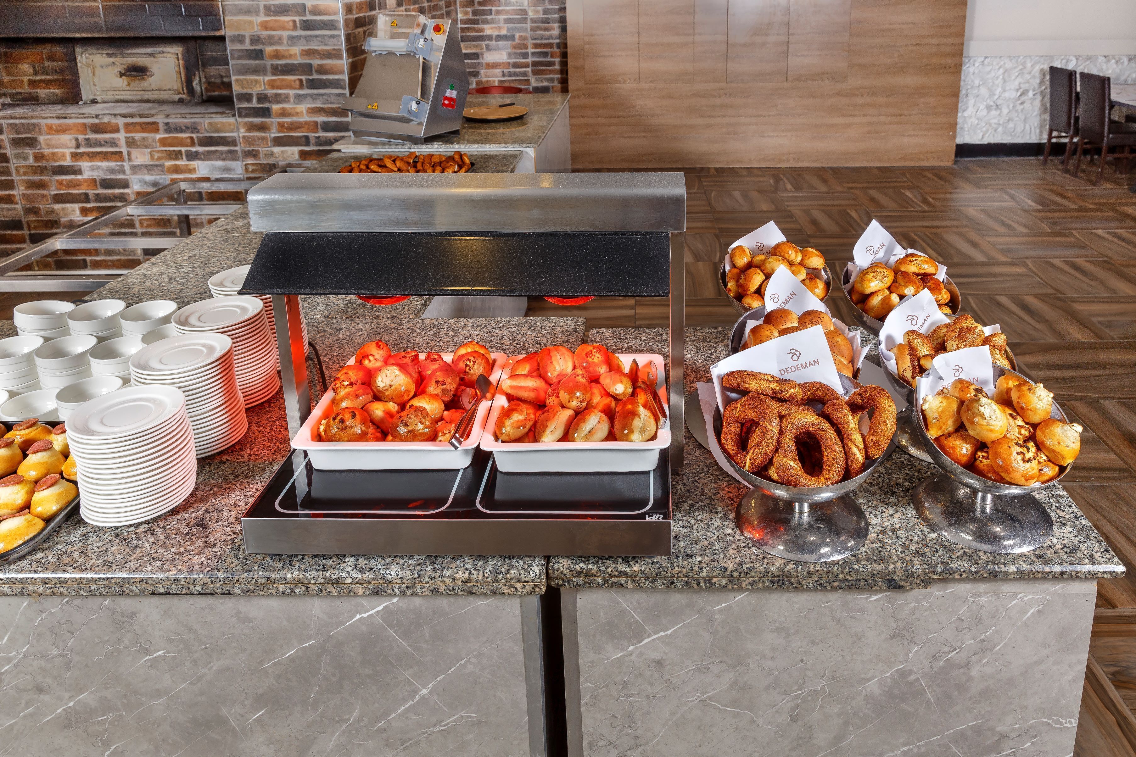 Ein Buffet mit verschiedenen Speisen, darunter Bratkartoffeln, Tomatenscheiben und einer Auswahl an Gebäck.