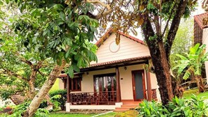 A house with a tiled roof, a porch with a railing, and a stone pathway leading to the entrance. - Hong Bin Bungalow Resort (Phu Quoc)