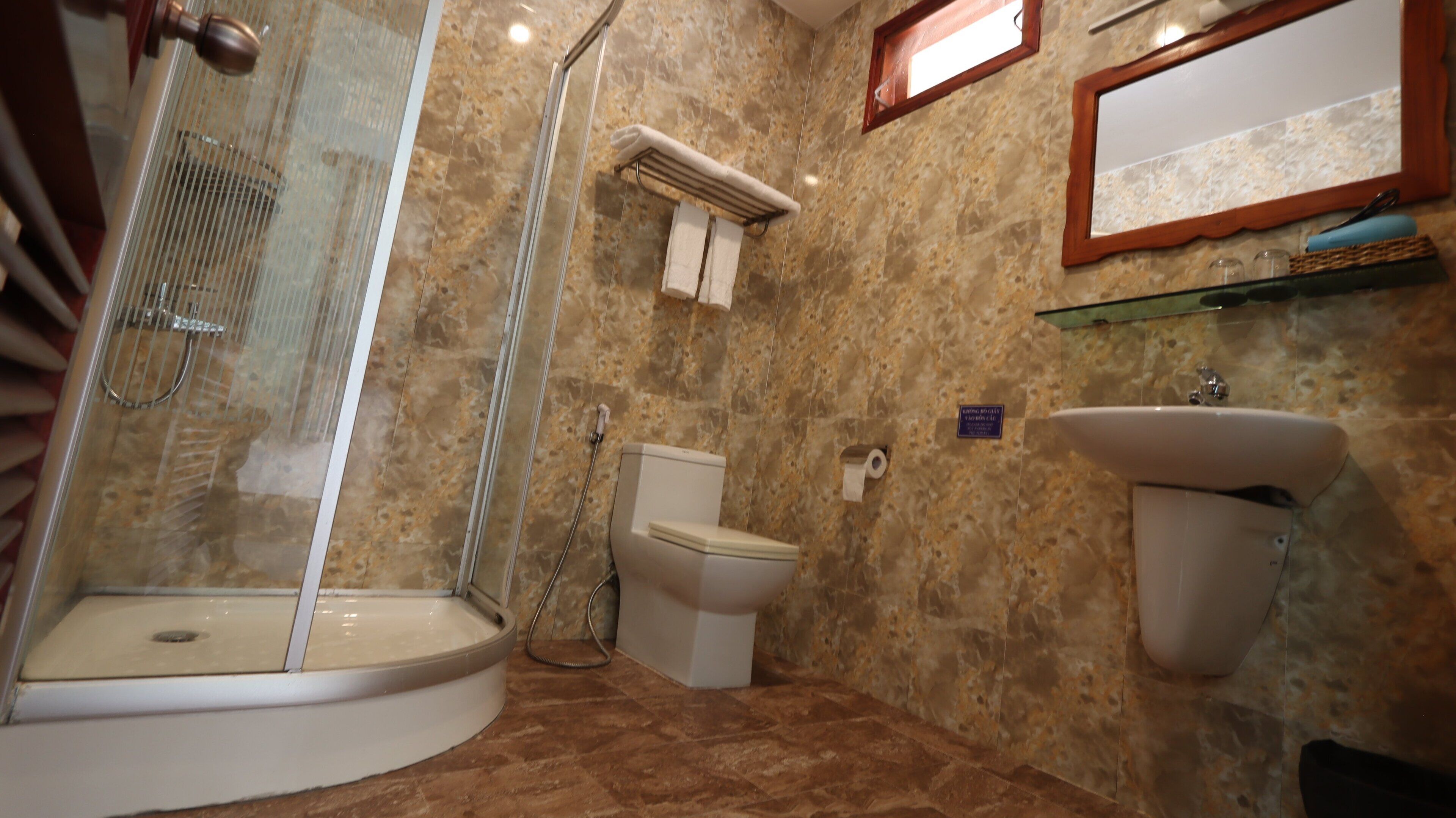 Ein Badezimmer mit Duschkabine, Toilette und Waschbecken.
