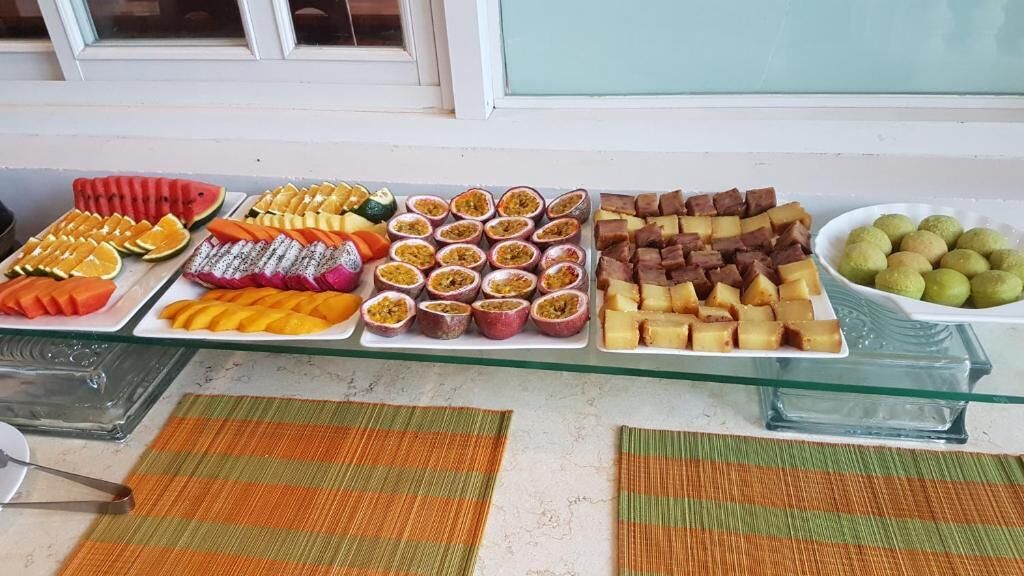 A buffet table with various fruits, pastries, and desserts.