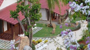 A model of a traditional house with a tiled roof, a garden with rocks and plants, and a pathway leading to the entrance. - Hong Bin Bungalow Resort (Phu Quoc)