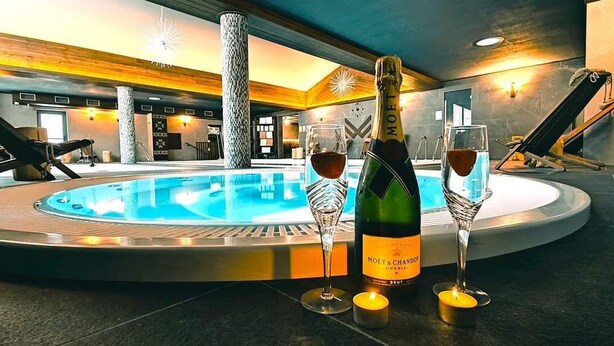 A pool area with a champagne bottle and glasses, a candle, and a lounge chair. - ARIETES MARMONT RESORT (Štrba)