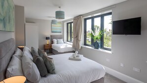 A modern bedroom with a large bed, a TV, and a window with curtains. - No.192 Oxford (Oxford)