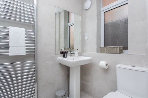 A modern bathroom with a white sink, mirror, and toilet. - No.192 Oxford (Oxford)