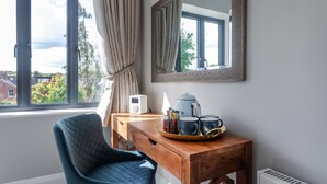 A room with a wooden table, a blue chair, a mirror, a window with curtains, and a radiator. - No.192 Oxford (Oxford)