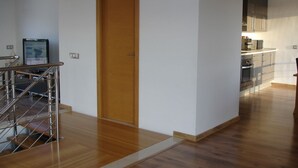 A modern apartment with a wooden door, a kitchen with stainless steel appliances, and a wooden staircase. - PICAFORT2, PRIVATE POOL, free wifi, beach, air conditioning, barbecue (IB)