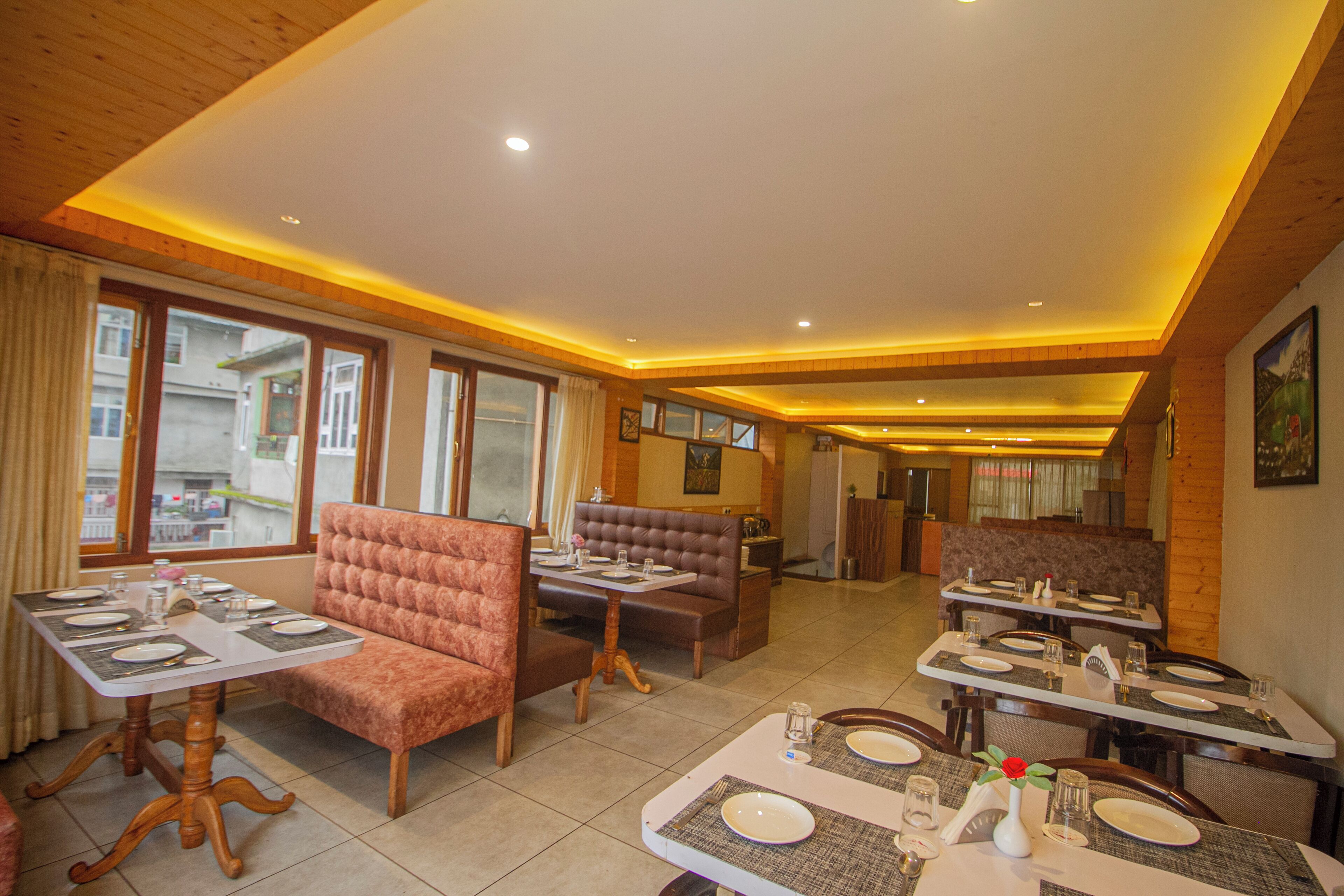 A dining area with multiple tables and booths, equipped with plates, glasses, and cutlery.