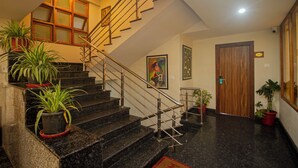 Una escalera con barandillas de metal y plantas en macetas en la base.