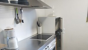 Een moderne keuken met een roestvrijstalen afzuigkap, een inbouwoven en een vaatwasser.