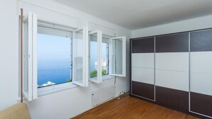 A room with a large window, a radiator, and a dark-colored wardrobe. - Apartment Rea (Dubrovnik)