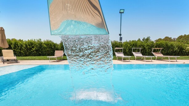 Une piscine d’un bleu éclatant agrémentée d’un élément décoratif aquatique.