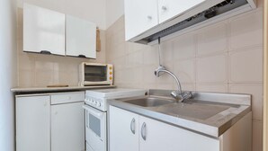 A kitchen with white cabinets, a microwave, an oven, and a sink. - 3033 Villetta Angela by Barbarhouse (Melendugno)
