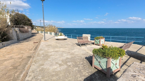 A coastal walkway with stone flooring, benches, and planters. - 2989 Villetta Mito - Mito A by Barbarhouse (Tricase)