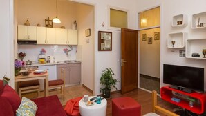 A compact living space with a kitchenette, a dining area, a TV, and a small seating area. - Sweetest Thing Apartment (Dubrovnik)