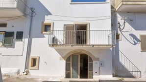 A white building with a balcony, a door, and a window. - 2923 La Casa Della Nonna by Barbarhouse (Carpignano Salentino)
