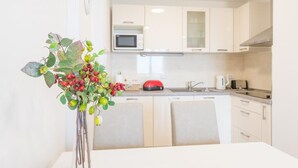 A modern kitchen with white cabinets, a microwave, a toaster, and a sink. - Apartment Luce Royal (Dubrovnik)