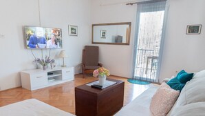 A modern living room with a sofa, coffee table, and TV. - Country Home Matkovic - Duba (Konavle)