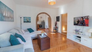 A modern living room with a sofa, coffee table, TV, and artwork on the walls. - Country Home Matkovic - Duba (Konavle)