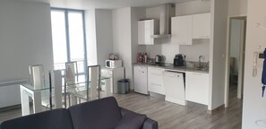 Una cocina moderna con gabinetes blancos, microondas, cafetera y lavavajillas.