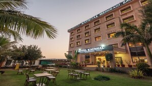 A hotel with a sign reading "Hotel Kaushal International" and outdoor seating. - Hotel Kaushal International (Sanchor)