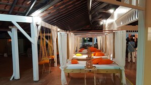 A room with a long bed, white curtains, orange pillows, and a small table with a basket. - Studio with sea view, beach, air conditioning, swimming pool, bar-restaurant, car rental (Sainte-Anne)
