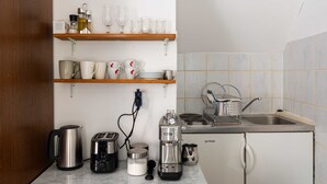 A compact kitchen with a coffee maker, toaster, kettle, and a sink. - Apartment Taura (Dubrovnik)