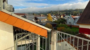 Zona residencial com casas, céu claro e vista distante de uma cidade.