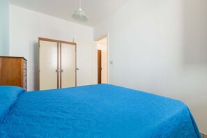 A bedroom with a bed, a wardrobe, and a door.