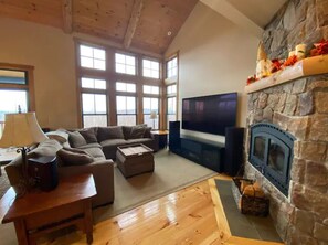 Relax in this inviting living room with a stone fireplace, flat-screen TV, and comfortable seating area.