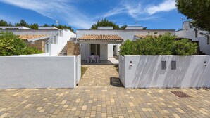 A courtyard with a paved walkway leading to a small seating area with tables and chairs. - 2371 Villette Girovagando - Trilo Superior by Barbarhouse (Melendugno)