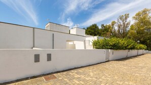 A paved courtyard with a white wall and a small garden area. - 2371 Villette Girovagando - Trilo Superior by Barbarhouse (Melendugno)