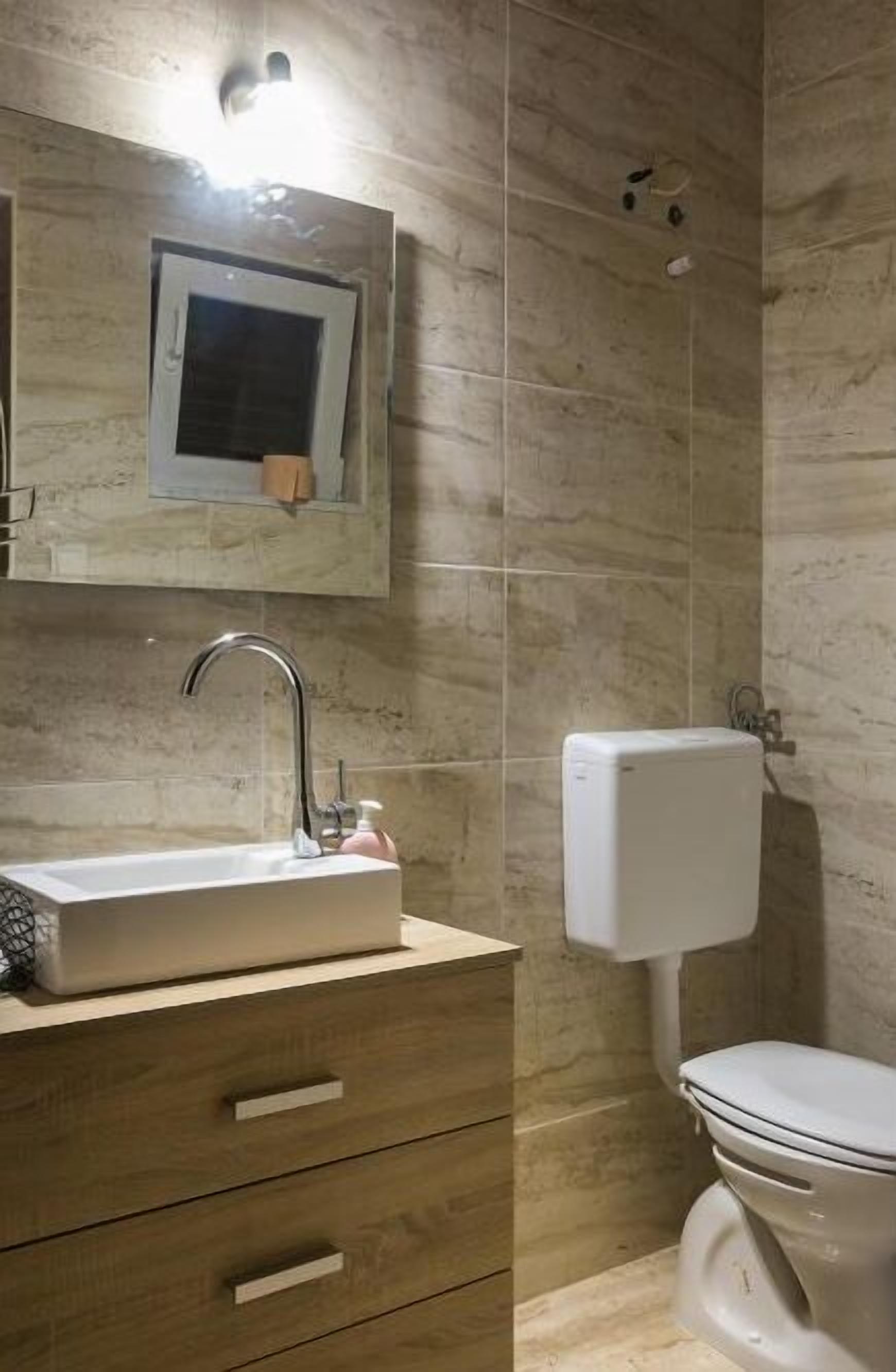 Ein Badezimmer mit Waschbecken, Spiegel und Toilette.