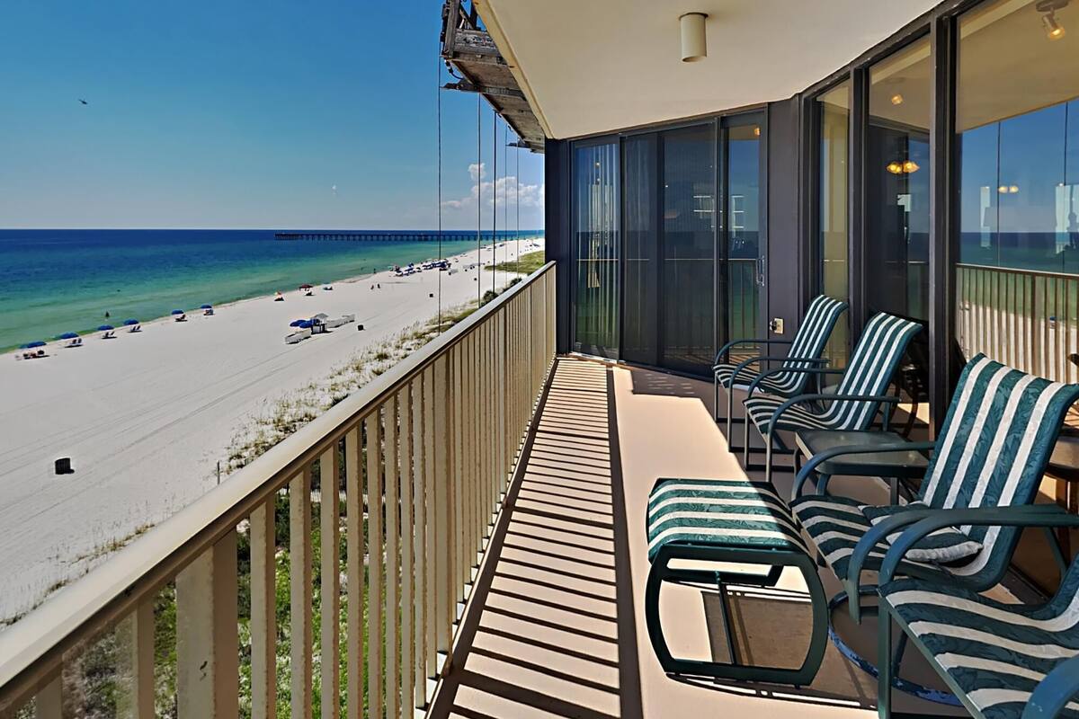 Ein Balkon mit Blick auf Strand und Meer.