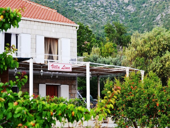 A two-story building with a balcony and a sign that reads "Villa Lina".