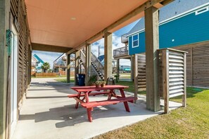 Ein überdachter Patio-Bereich mit Picknicktischen und einem Holzzaun.