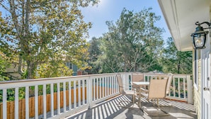 Un balcon avec une balustrade blanche, une table et des chaises.