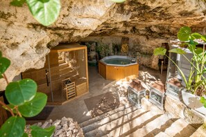 Zona de spa con un armario de madera, un jacuzzi y faroles.
