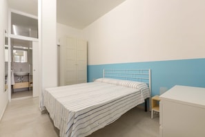 A bedroom with a bed, a nightstand, a desk, and a wardrobe. - 3038 La Casa di Maristella- Bilo by Barbarhouse (Otranto)