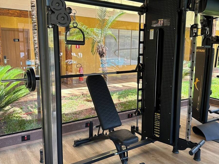 Un gimnasio con banca de pesas, una estructura para sentadillas y diversas máquinas de pesas.