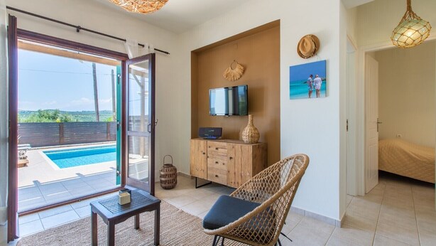 A modern living room with a pool view, a TV, and a wicker chair. - Private pool★Wifi★SeaView★Quiet place★Roof terrace (Darmarohori)