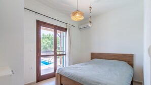 A bedroom with a wooden bed, a view of a swimming pool, and a hanging light fixture. - Private pool★Wifi★SeaView★Quiet place★Roof terrace (Darmarohori)