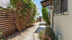 A narrow alleyway with a wooden fence on one side and a building on the other. There are potted plants and a gravel path. - Private pool★Wifi★SeaView★Quiet place★Roof terrace (Darmarohori)