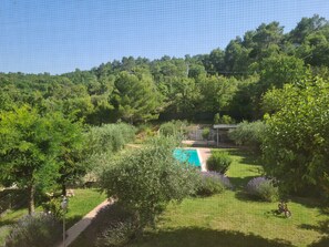 A backyard with a swimming pool, surrounded by lush greenery and trees. - Summer Sale! Lovely 3-bed Apartment in Spoleto (Spoleto)