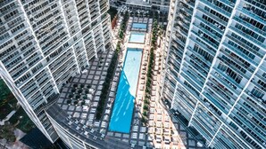 A high-rise building with a rooftop swimming pool surrounded by lounge chairs and sunbeds. - ICON W BRICKELL EXCLUSIVE OCEAN VIEW 2BR/1BA #2909 (Miami)