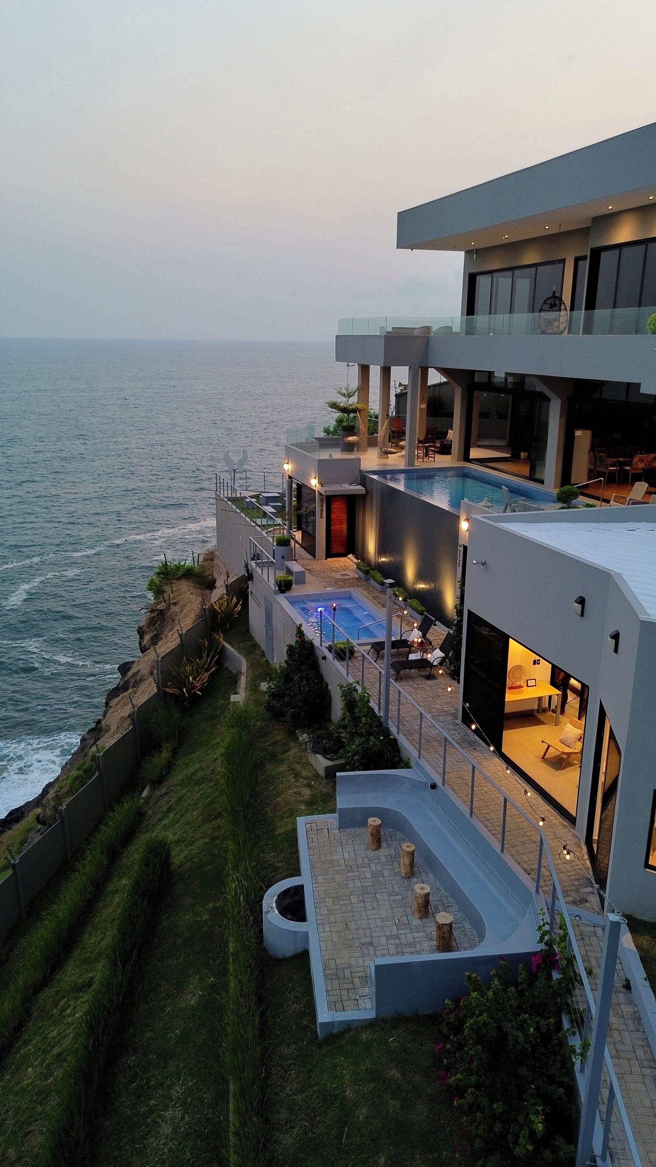 Uma propriedade costeira moderna com piscina, área de estar externa e vista para o oceano.