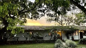 A house with a tiled roof, surrounded by lush greenery and trees. - MuchoSur Quimbaya (Quimbaya)