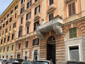 A multi-story building with a classical architectural style, featuring arched windows and decorative stonework.