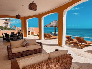 A beachside lounge with wicker furniture, a thatched umbrella, and a view of the ocean. - HT: Elegant Villa with Private Infinity Pool for 14 Guests (Tulum)