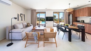 A modern living room with a sofa, coffee table, and dining area.
